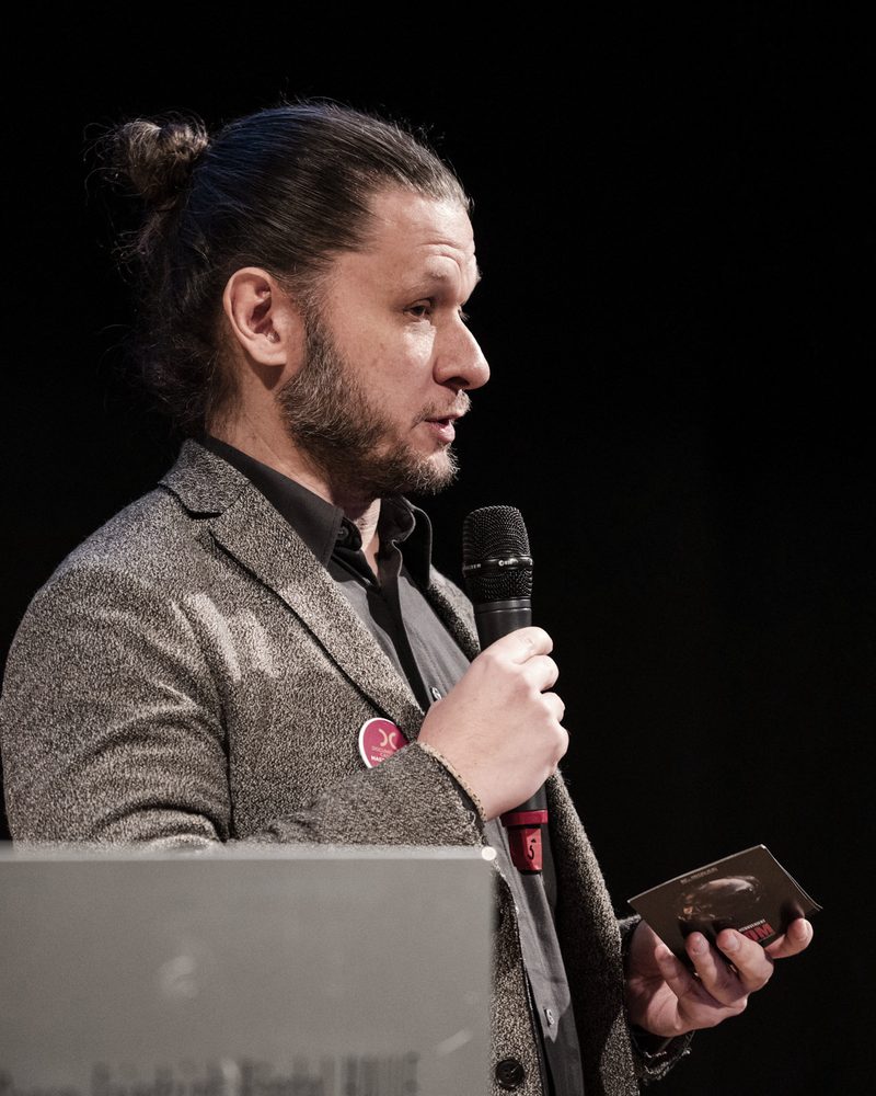Niki Drozdowski pitching An Inconvenient Doom on stage